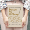 engrave my wellbeing affirmation coloring book held by a model